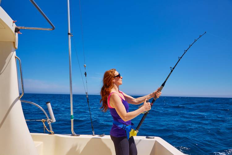 woman fishing in the ocean on a boat