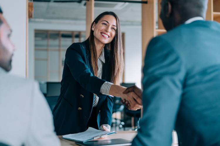 woman shaking a man's hand after ending a meeting