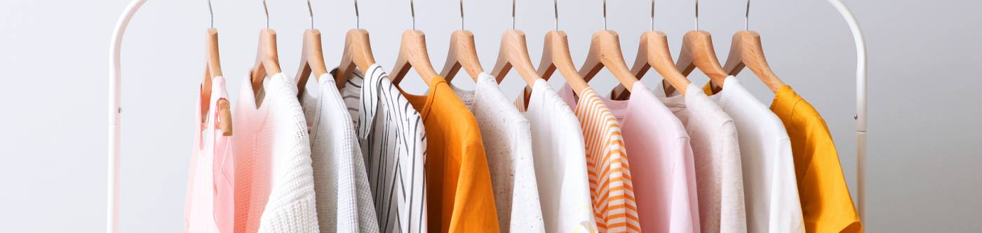 rack of clothing in orange, pick, and white colors